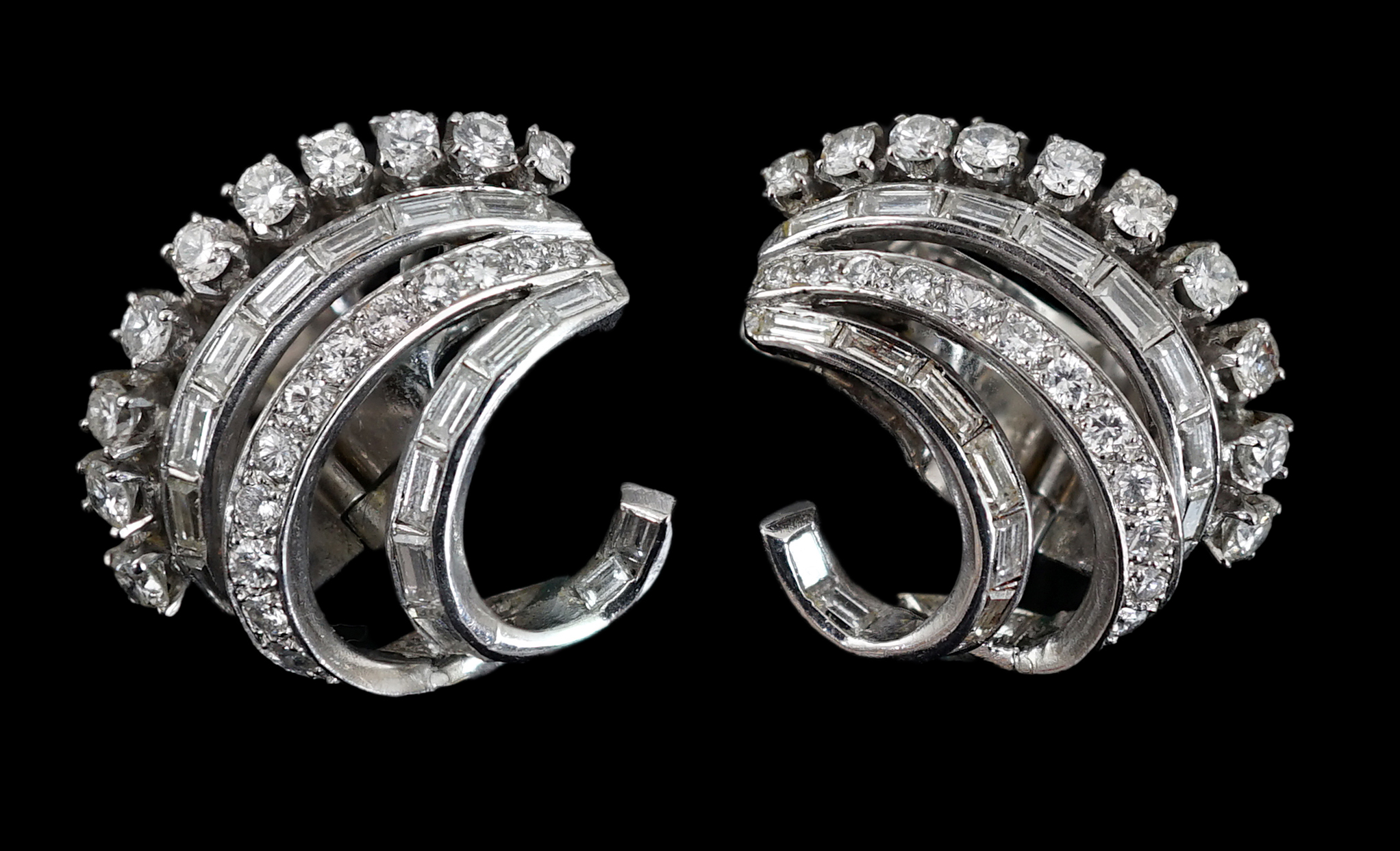 A pair of platinum? and diamond cluster set scrolling earrings